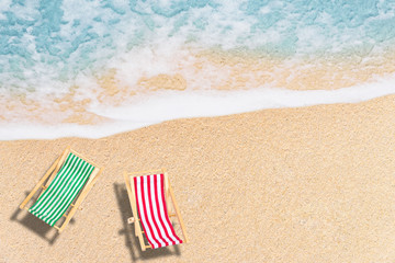 Summer Vacation and Holiday Trip Concept : Top view  of Beach chairs on sand beach with white wave and blue sea.