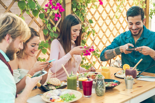 Young people Making photos to the food and smoothie bowls. Happy friends having a healthy lunch in restaurant outdoor. Food and drink trends concept - Image