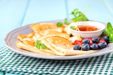 Pancakes with jam and berries on a table. Selective focus. Copy space.