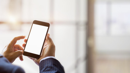 Close up view of using blank screen smartphone with blurred office room background