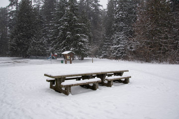 A picture of the snow-covered picnic table on the ground.   Burnaby BC Canada