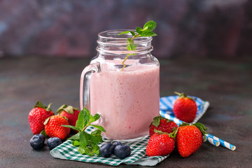 Smoothie in a jar and berries on a table. Selective focus. Copy space.