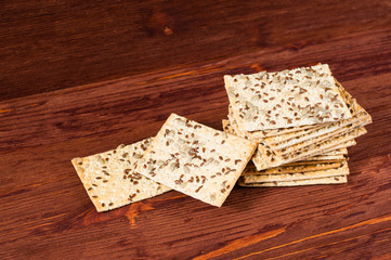 Stack of crispy wheat cakes with sesame seeds, flax and sunflower on a red wooden background. vegetarian food, eco food concepts
