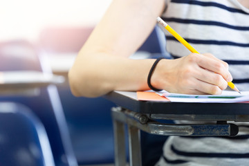 high school,university student study.hands holding pencil writing paper answer sheet.sitting lecture chair taking final exam attending in examination classroom.concept scholarship for education abroad