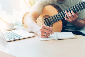 Fototapeta premium artist songwriter thinking writing notes,lyrics in book at studio.man playing live acoustic guitar relax chill.concept for musician creative.composer work process.people relaxing time with instrument