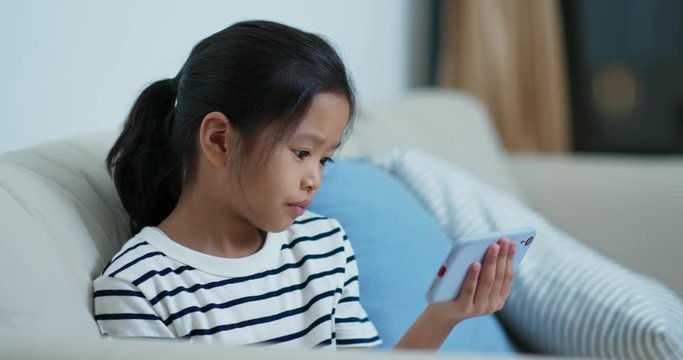 Little girl watch on cellphone at home