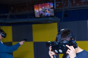 The guy’s head is a mask connected to a black helmet for immersion in virtual reality with a 3D...