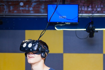 The guy’s head is a mask connected to a black helmet for immersion in virtual reality with a 3D...