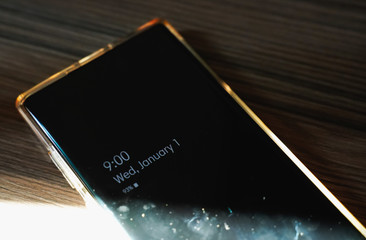 Close up of mobile smart phone on 1 January 9:00 AM calendar on new year with screen of dust...