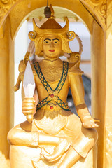 Sitting golden angle statue holding white knife at the temple.