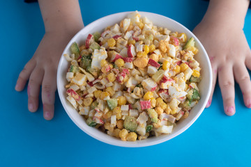 Fresh salad with different kinds of fruits and berries. Kids hands