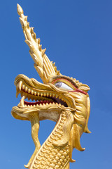 Golden dragon's head at the temple with blue sky background.