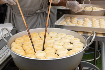 Deep frying doughnuts in hot oil. Made of fresh ingredients tasty.