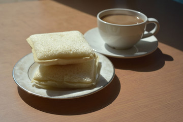 Coffee and bread on a wooden table in the morning