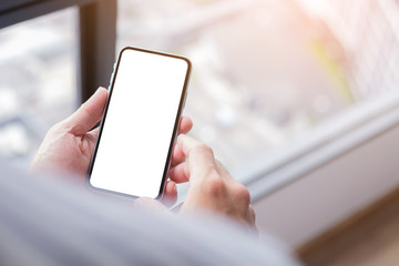 Mockup image blank white screen cell phone.man hand holding texting using mobile sitting at coffee shop.background empty space for advertise text.people contact marketing business,technology 