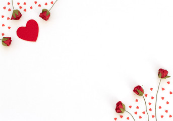 Red roses and a lot of small red hearts on white background. Valentine's Day, Spring, birthday, wedding, love, Mother’s Day concept. Greeting, invitation card. Flat lay with copy space for text.