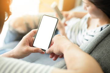 Mockup image blank white screen cell phone.man hand holding texting using mobile sitting at coffee shop.background empty space for advertise text.people contact marketing business,technology 