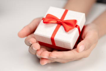 Hands holding small gift box.