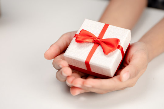 Hands holding small gift box.