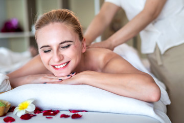 Obraz na płótnie Canvas Beautiful young attractive Caucasian woman having body massage by Thai Masseur in spa salon. Beauty treatment and body care lifestyle concept.