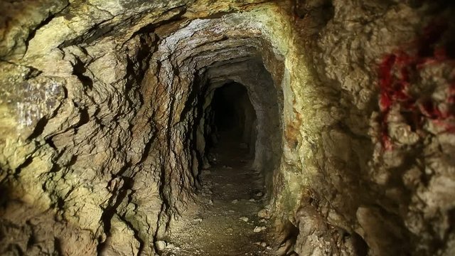 Flashlight illuminating inside of abandoned gold mine