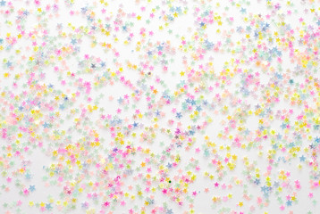 Gold stars confetti abstract pattern on a white background. Holiday concept, top view.