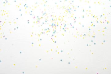 Gold stars confetti abstract pattern on a white background. Holiday concept, top view.