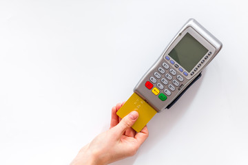Payments in shops. Hand insert bank card in terminal on white background top-down copy space