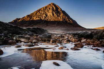 Buachaille Etive mor mountain, glencoe, highlands, Scotland, uk. morning sunrise hitting the peak with frozen river. © cliff