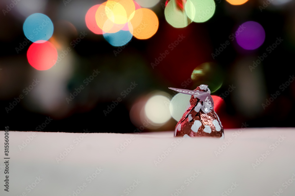 Poster chocolate is wrapped in an inverted cone shape. against the bokeh background
