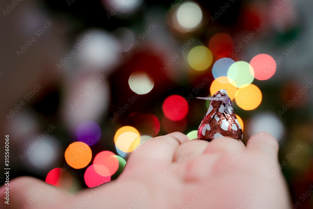 Poster chocolate is wrapped in an inverted cone shape. against the bokeh background