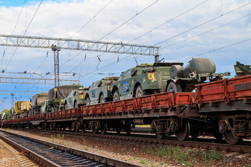 Cargo train carrying military vehicles on railway flat wagons