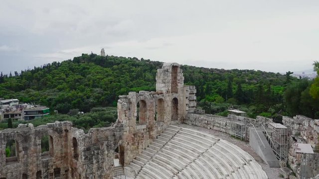 Static shot of the Philopappou Hill ancient monument stood behind the Odeon of Herodes Atticus Roman theater in Athens, Greece.