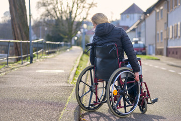 Fototapeta na wymiar Handicapped woman manoeuvring her wheelchair