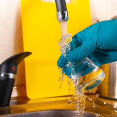 water purification specialist tap water pours into a glass flask.