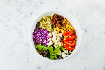 Vegetarian buddha bowl. Raw vegetables, tofu and bulgur in white bowl. Vegetarian, healthy, detox food concept