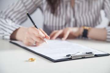 Young woman signing decree of divorce.