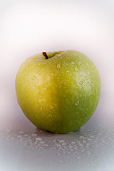 green apple with water drops on a white background