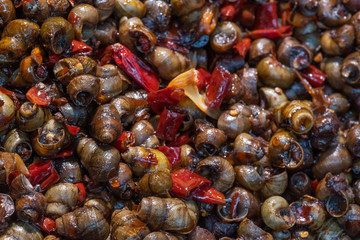field snail stir fried with chili sauce on a market in Chengdu, Sichuan province, China