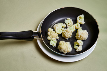 Cooking. Broccoli on a pan on a light background