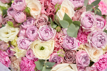 European floral shop. Beautiful bouquet of mixed flowers in womans hands. the work of the florist at a flower shop. Delivery fresh cut flower.