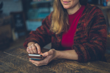 Young woman using smartphone in cafe