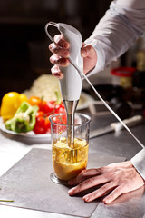 Beating of homemade mayonnaise with olive oil. Mix ingredients for sauce. The chef uses a blender. Step by step sauce preparation