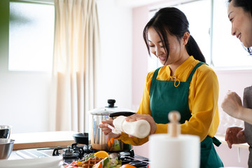 母に料理の仕方を習う娘