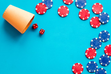 Poker frame. Chips and dices on blue background top-down copy space