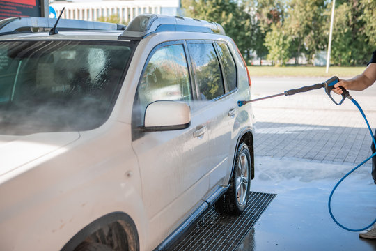 strong man washing car at self carwash outdoors