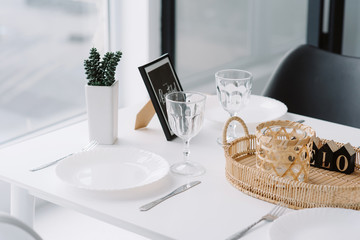 White dining table near the window. A stylish breakfast place. Modern kitchen interior.