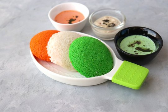 Tiranga Idli or Tricolor Idly cooked in  Indian National Flag colors - saffron or orange, white and green. Served with tiranga chutney. Concept for Indian Independence or Republic day greeting card. 