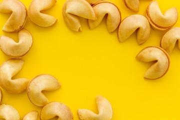 Fortune cookie frame on yellow background top-down copy space