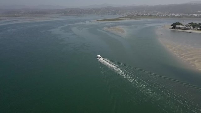 Tour boat returns to port, avoiding sand bars in Knysna Lagoon, aerial